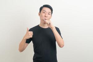 porträtt ung asiatisk man borsta tänderna foto