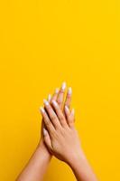 vacker nagel kvinna spa manikyr och händer närbild vacker kvinna händer manikyrerade naglar och mjuk hud bred banner skönhetsbehandling vacker kvinna naglar med gul bakgrund skönhetskoncept foto