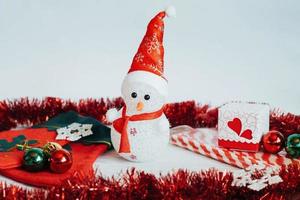 lätt snögubbe docka och juldekorationer på en vit trä b foto