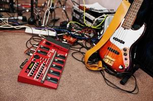 elbasgitarr och gitarrljudbehandlingseffekter på ett studiogolv. foto