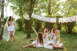 flickor som bär vita klänningar som har roligt på möhippo. foto