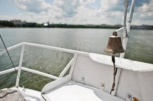 järnklocka på en liten yacht vid sjön. foto