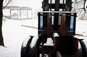 rostig gammal sovjetisk traktor täckt av snö. foto