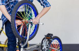 selektiv fokusering av pojkehandfixande cykel, mekanisk hobby och reparationskoncept. foto