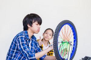 bror och syster fixar cykel tillsammans, pojke och flicka reparerar cykel foto