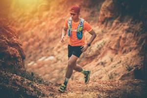 en man löpare av trail och atlets fötter bär sportskor för trail löpning i berget foto