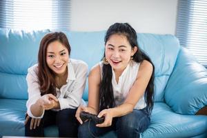 två kvinnor tävlingsvänner som spelar videospel och glada glada glada hemma foto
