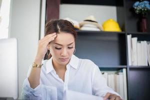 asiatisk affärskvinna och kvinnor studerar seriöst om läsboken och jobbar hårt tills huvudvärken foto