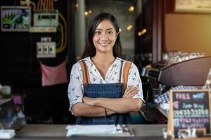 asiatiska kvinnor barista leende och använda kaffemaskin i kafédisk - arbetande kvinna småföretagare mat och dryck café koncept foto