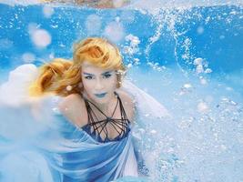 undervattens mode porträtt av vacker blond ung kvinna i blå klänning foto