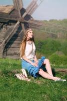 ung vacker blond flicka med långt hår i grönt fält i utomhus etnisk by i Kiev Ukraina foto