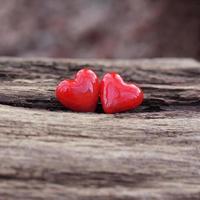 två röda keramiska hjärtan på trä bakgrund med kopia utrymme foto