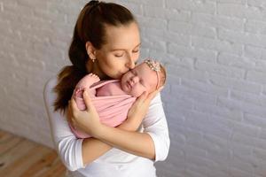 kärleksfull mamma som tar hand om sitt nyfödda barn hemma foto