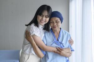 cancerpatient kvinna bär huvudduk och hennes stödjande dotter på sjukhus, hälsa och försäkring koncept. foto