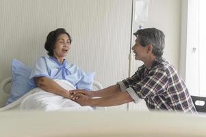 senior man besöker senior patient kvinna på sjukhus, hälsovård och medicinsk koncept foto