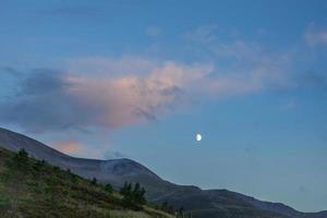 månen stiger över cairngormbergen foto