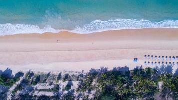 Flygfoto uppifrån och ner av kokospalmer på den vackra karon stranden phuket thailand fantastisk havsstrand sand turistresmål i Andamansjön vacker ö foto