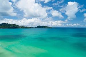 flygfoto över blått hav ytvatten textur bakgrund drönare flyger över havets vågor vatten ytstruktur på soligt tropiskt hav i phuket island thailand.travel och turné bakgrund foto