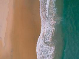 flygfoto sandstrand och vågor vackert tropiskt hav på morgonen sommarsäsong bild av flygfoto drönare, hög vinkel uppifrån havets vågor foto