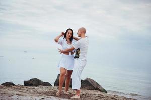 vackra inflammatoriska par som dansar på stranden foto