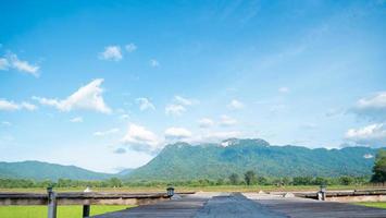 balkong eller träbro som sträcker sig till fälten för att vara en utsiktsplats det håller på att bli ett populärt turistmål i thailand. vidsträckta risfält intill berg, vacker natur, klar himmel. foto