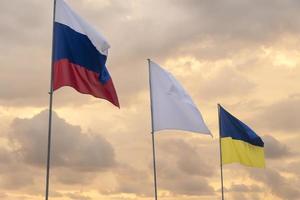 flaggor vajar vid solnedgången. Ryssland och Ukraina. foto