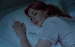 ung kvinna sover i sängen på natten foto