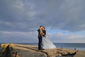 bröllop fotosession av ett par på stranden. blå bröllopsklänning på bruden. foto