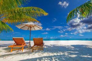 lugn strandscen, par stolar, paraply. exotiska tropiska strandlandskap destination för bakgrund eller tapeter. design av romantiska sommarsemester semester koncept.