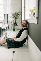 stilig mogen modig snygg skotsk affärsman i kilt och kostym i badrummet. stil, arbeta hemifrån, mode, livsstil, kultur, etniskt koncept. foto