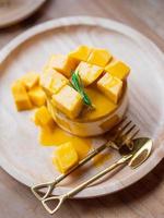 söt gul mango cheesecake på rund träbricka. foto