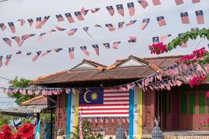 traditionellt trähus dekorerat med Malaysias flagga foto