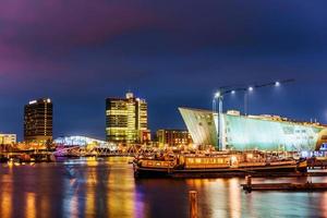 vacker natt i amsterdam. belysning av byggnader foto