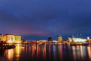 vacker natt i amsterdam. belysning av byggnader foto