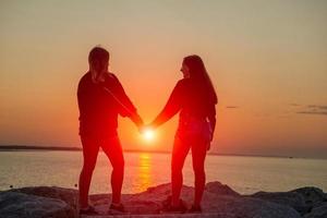 flickor kramades vid solnedgången foto