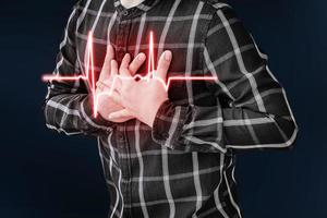 en vuxen man använder sin hand för att hålla hans bröst. efter att ha haft ett hjärtinfarktsymtom. foto