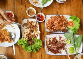 familj lunch mat på träbord med all lokal mat äta med thai ångat ris. foto