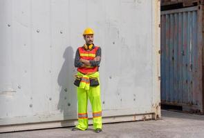 ingenjör man i hjälm stående med armarna i kors vid containerlast foto