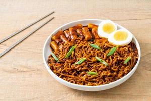 jjajang rabokki - koreanska snabbnudlar eller ramyeon med koreansk riskaka eller tteokbokki och ägg i svart bönsås foto