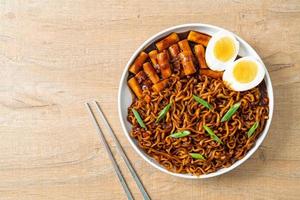 jjajang rabokki - koreanska snabbnudlar eller ramyeon med koreansk riskaka eller tteokbokki och ägg i svart bönsås foto