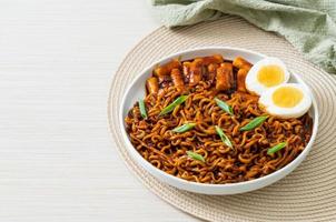 jjajang rabokki - koreanska snabbnudlar eller ramyeon med koreansk riskaka eller tteokbokki och ägg i svart bönsås foto