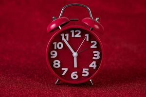 röd bakgrundsbild och vacker röd väckarklocka koncept, tid, datum foto