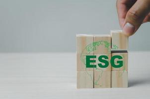 hand sätta träkuber med esg miljömässig social styrning symbol på tabellen kopia space.business koncept. foto