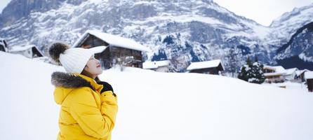 grindelwald schweiz toppen av Europa, asiatisk kvinna som bär gul coat.she använder smartphone ta ett foto snö berg i sin semester på bergen, resa resa snöig vinter på berget vid grindelwald.