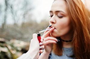 hand av flicka med cigarettändare. sluta röka sociala problem. vänner röker. foto