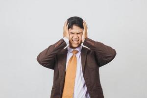 asiatisk affärsman i kostym och slips ser frustrerad ut eller har svår huvudvärk foto
