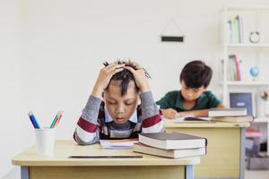 stressad asiatisk student under examen i klassrummet foto