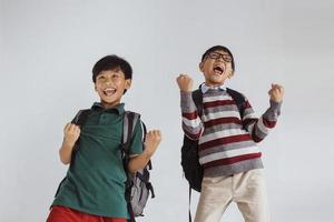 två glada elever med vinnande gest för tillbaka till skolan-konceptet foto