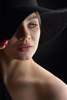 vacker kvinna i hatt. retro mode. mörk bakgrund. foto