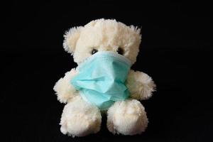 liten nallebjörn i en medicinsk mask foto